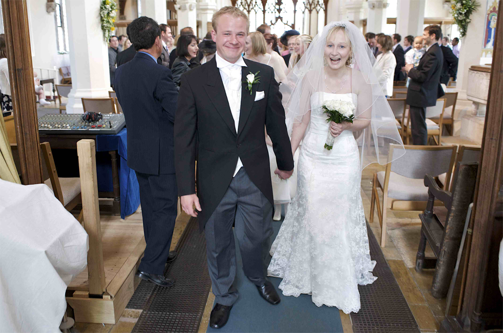 Gill and Alan walking out of the church after getting married by cambridge based photographer Richard Bowring